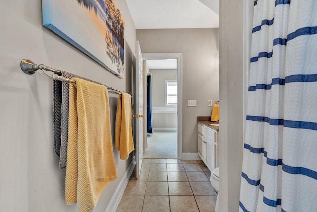 bathroom featuring tile patterned flooring, vanity, toilet, and walk in shower