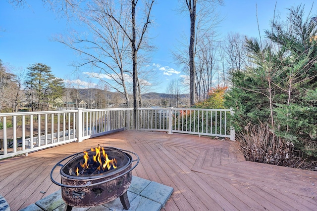 wooden terrace featuring a mountain view and an outdoor fire pit