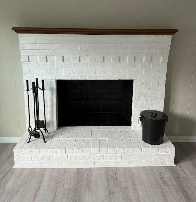 room details featuring a brick fireplace and hardwood / wood-style floors