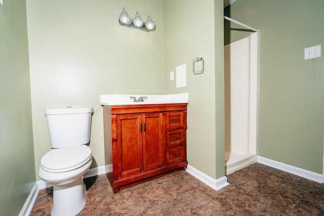 bathroom featuring toilet, a shower, and vanity