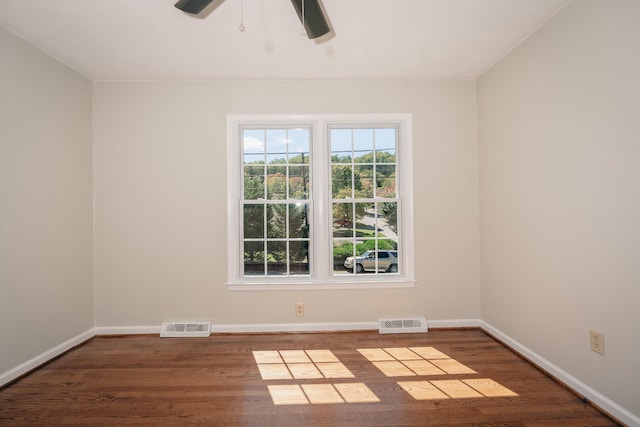 unfurnished room featuring dark wood-type flooring and ceiling fan