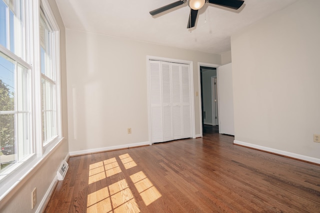 empty room with ceiling fan and dark hardwood / wood-style flooring