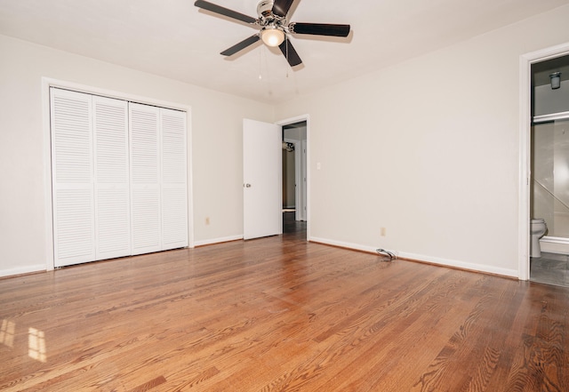 unfurnished bedroom with ceiling fan, hardwood / wood-style floors, ensuite bathroom, and a closet