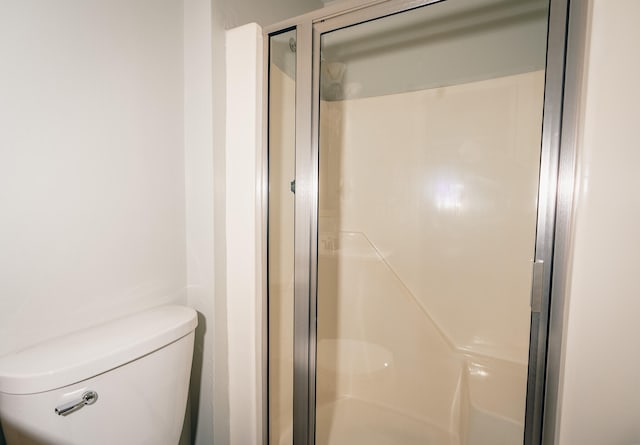 bathroom featuring an enclosed shower and toilet