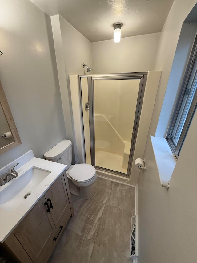 bathroom featuring vanity, toilet, and walk in shower