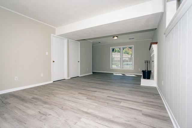 unfurnished living room featuring a fireplace and light hardwood / wood-style flooring