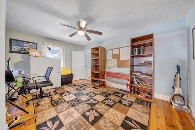 office area with a textured ceiling, hardwood / wood-style floors, and ceiling fan