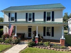 farmhouse inspired home featuring a front lawn