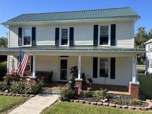 country-style home with a front lawn and a porch