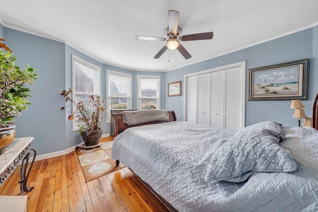 bedroom featuring ceiling fan, crown molding, a closet, and hardwood / wood-style floors