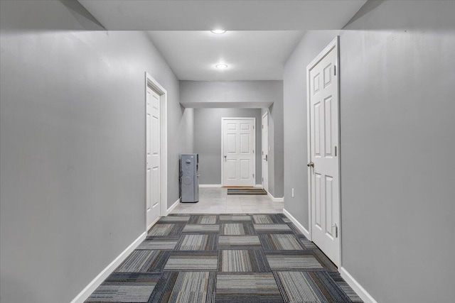 corridor featuring dark colored carpet