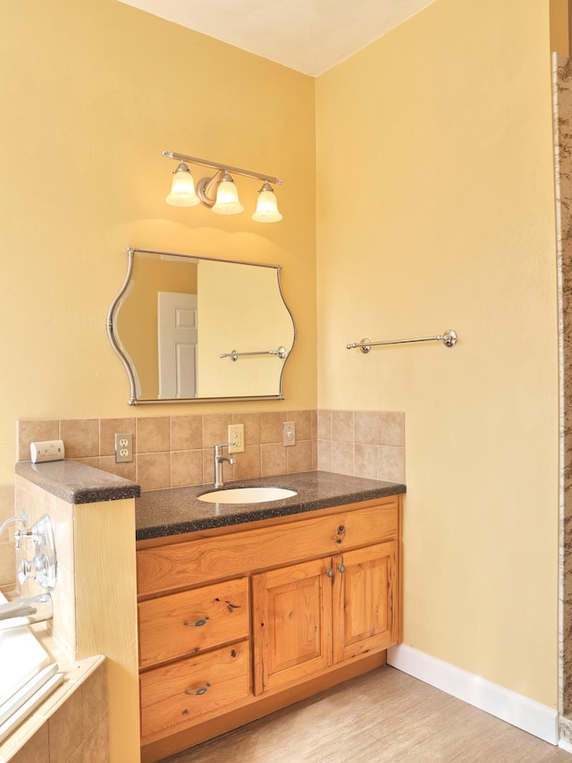 1782 Wolf Creek Rd, Narrows, VA 24124 - full bath featuring vanity, tasteful backsplash, wood finished floors, and a relaxing tiled tub