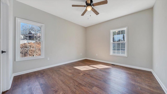 spare room with a ceiling fan, baseboards, and dark wood-style flooring