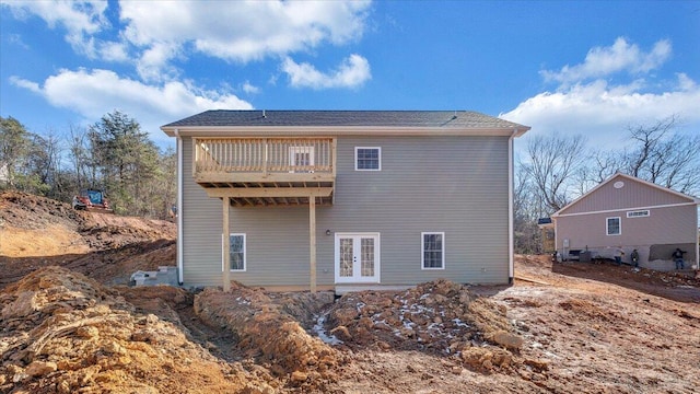 rear view of property with french doors and a balcony