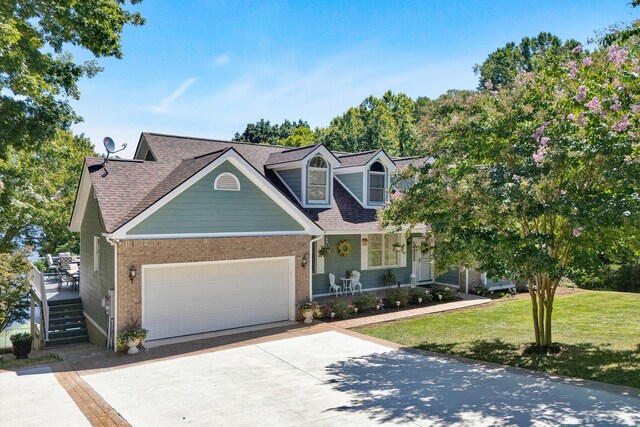 view of front of home with a garage, a front yard, and a porch