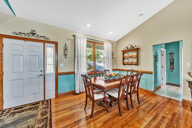 dining area featuring vaulted ceiling and light hardwood / wood-style floors