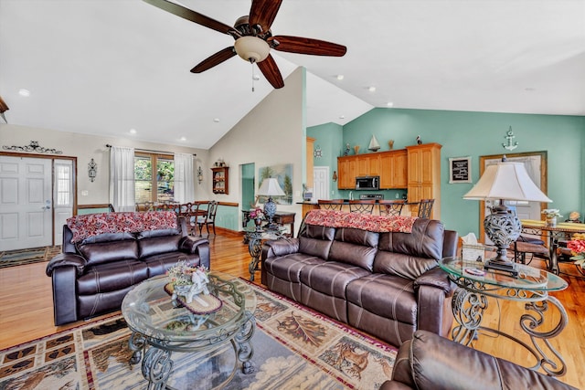 living room with lofted ceiling, wood-type flooring, and ceiling fan