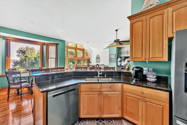 kitchen featuring light hardwood / wood-style flooring, appliances with stainless steel finishes, kitchen peninsula, sink, and ceiling fan