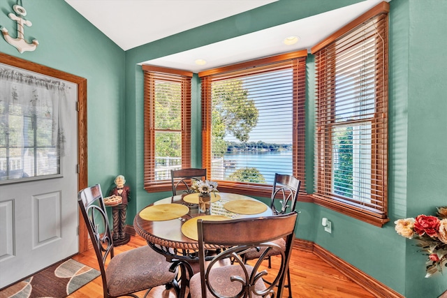 dining room with vaulted ceiling and light hardwood / wood-style floors