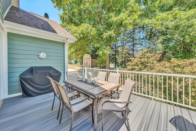 wooden deck featuring area for grilling and a shed