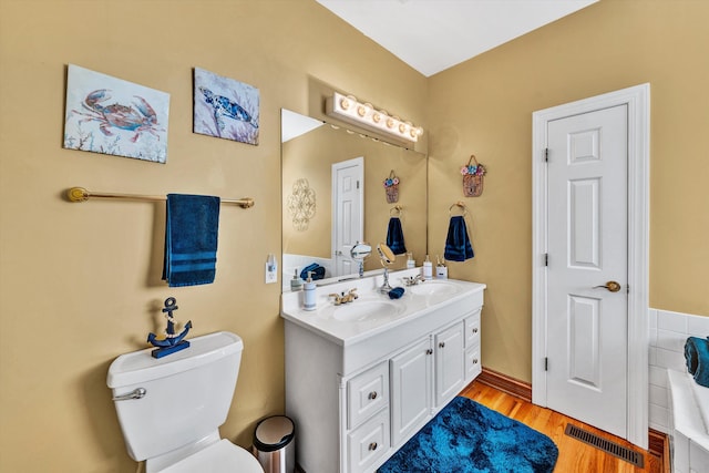 bathroom with hardwood / wood-style floors, toilet, and vanity