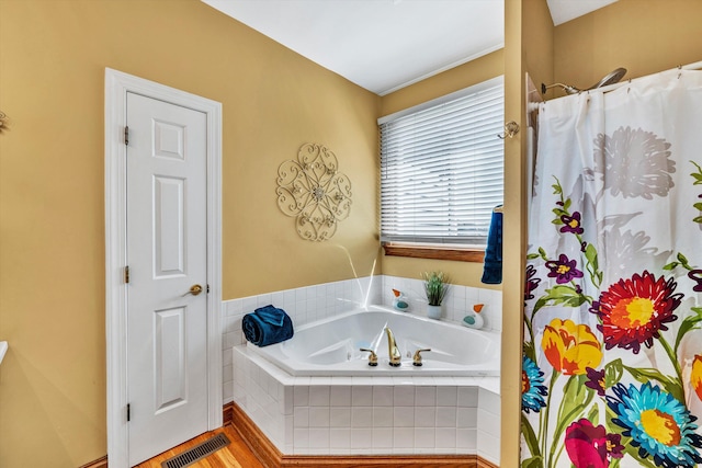 bathroom featuring shower with separate bathtub