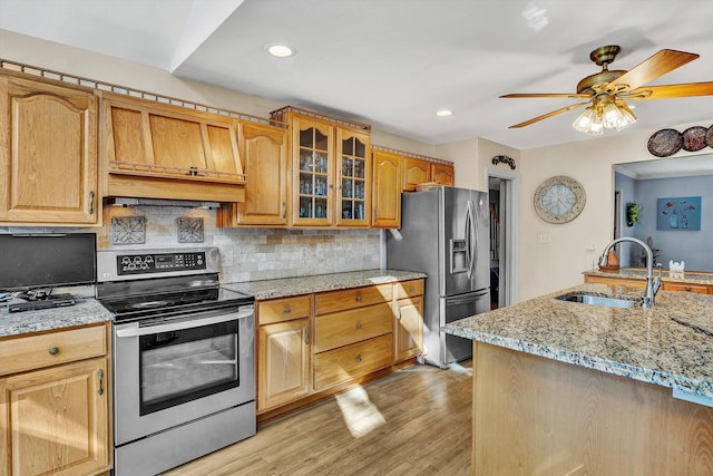 kitchen with ceiling fan, appliances with stainless steel finishes, sink, and light hardwood / wood-style flooring