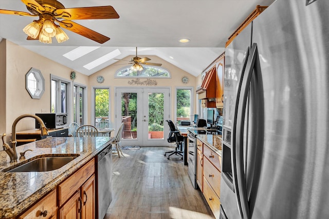 kitchen featuring stainless steel appliances, light hardwood / wood-style flooring, ceiling fan, french doors, and sink