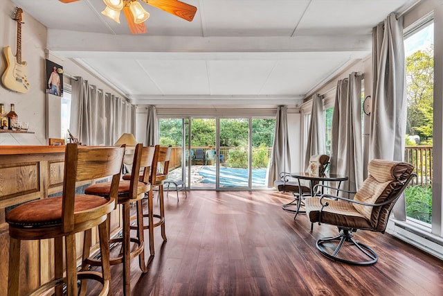 sunroom / solarium featuring beam ceiling and ceiling fan