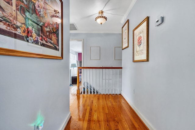 hallway featuring crown molding and light hardwood / wood-style floors