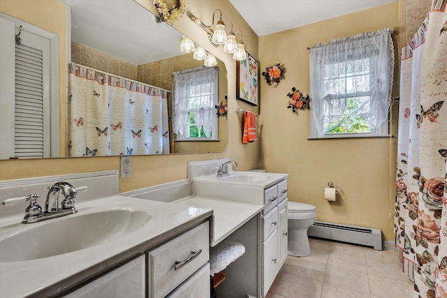 bathroom featuring a baseboard radiator, a wealth of natural light, vanity, and toilet