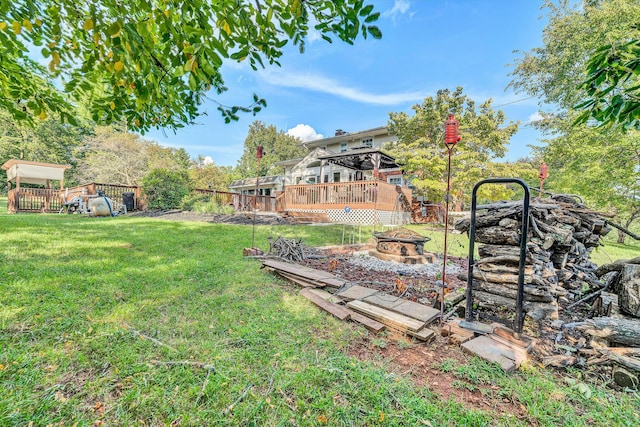 view of yard with a gazebo, a deck, and an outdoor fire pit