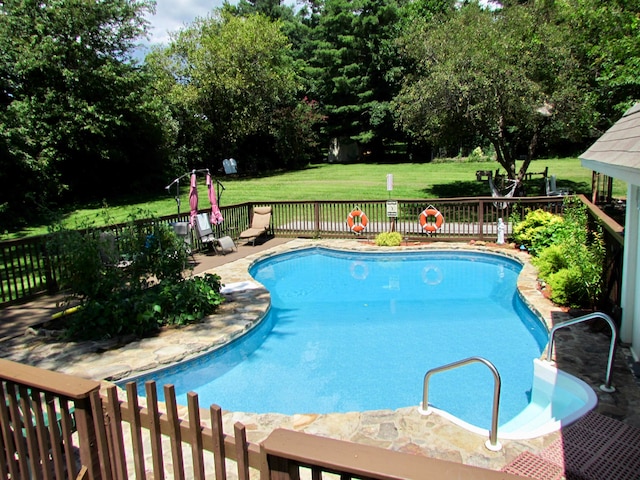 view of pool with a yard