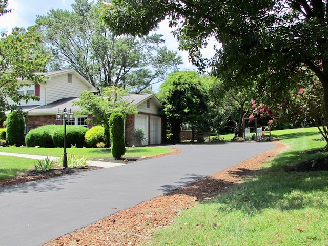 view of home's community featuring a lawn and a garage