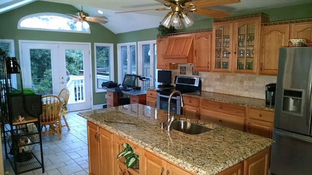 kitchen featuring sink, an island with sink, lofted ceiling, appliances with stainless steel finishes, and ceiling fan