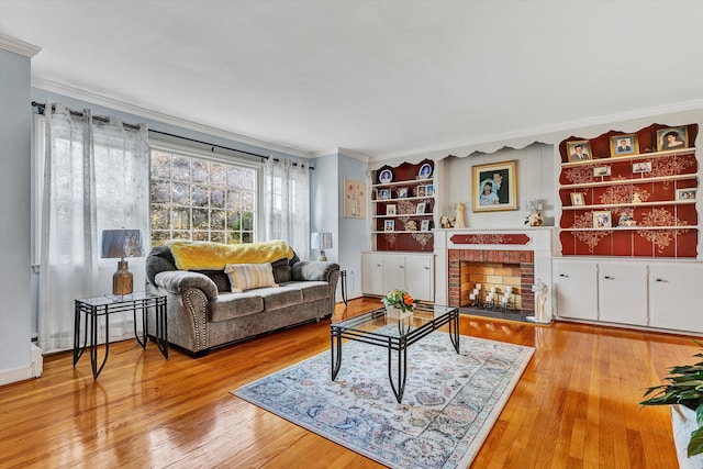 living room with wood-type flooring, a fireplace, and ornamental molding