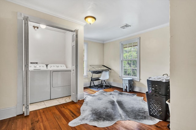 living area with wood-type flooring, separate washer and dryer, and crown molding