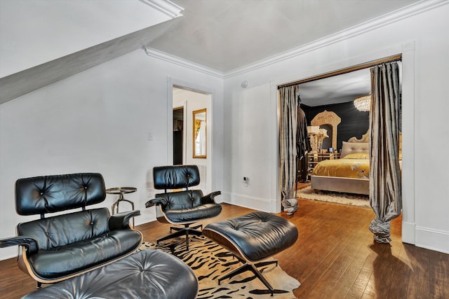 living area featuring crown molding and hardwood / wood-style flooring