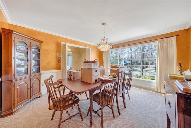 dining area featuring light carpet, an inviting chandelier, and ornamental molding