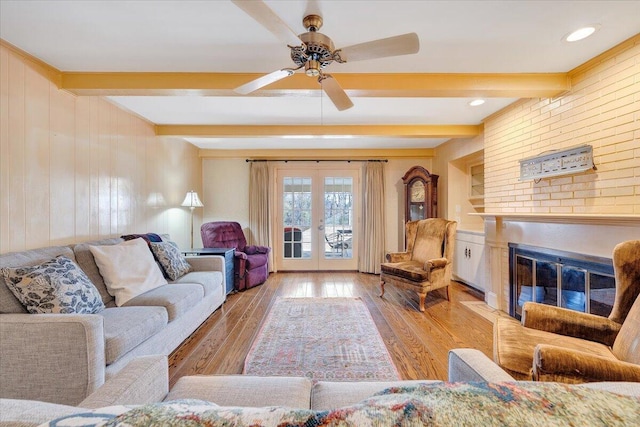 living room with beam ceiling, light hardwood / wood-style floors, and ceiling fan