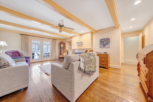 living room with ceiling fan, french doors, beamed ceiling, and light wood-type flooring