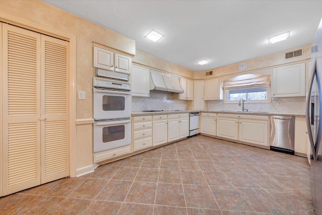 kitchen with decorative backsplash, sink, wall chimney exhaust hood, and white appliances