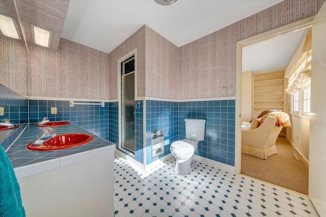 bathroom featuring an enclosed shower, toilet, and tile walls