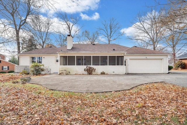 back of property featuring a sunroom and a garage