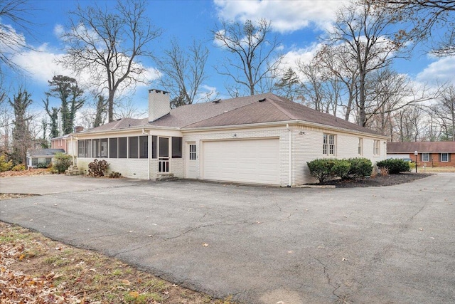 exterior space featuring a sunroom and a garage