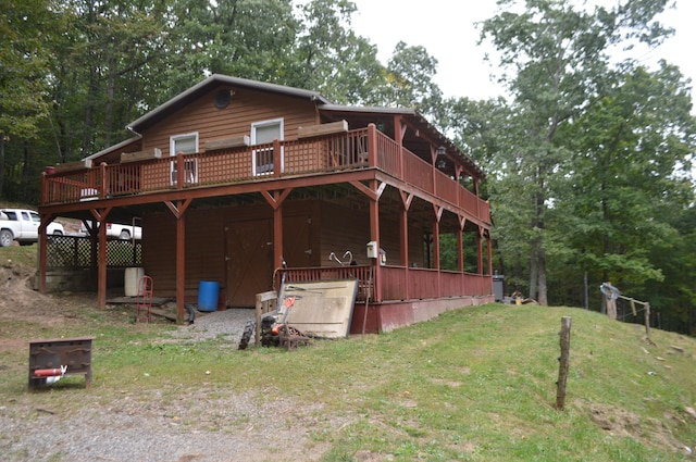 rear view of property with a yard and a wooden deck