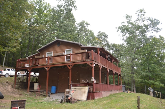 back of property featuring a deck and a yard