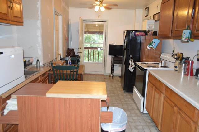 kitchen with ceiling fan, electric stove, brown cabinets, a center island, and light floors