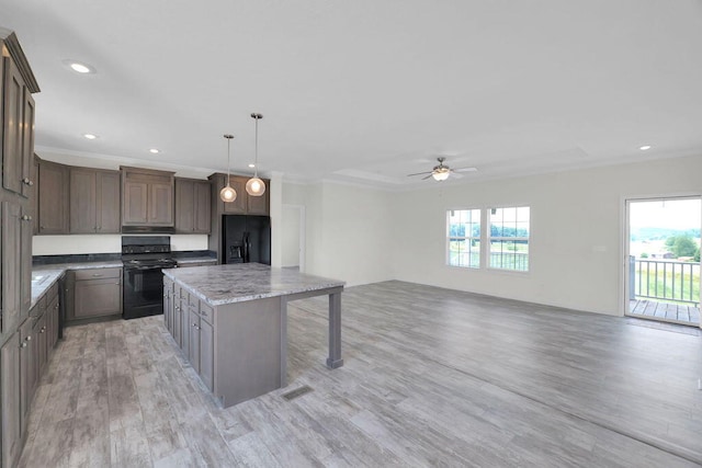 kitchen with light wood-type flooring, pendant lighting, black appliances, a kitchen island, and ceiling fan