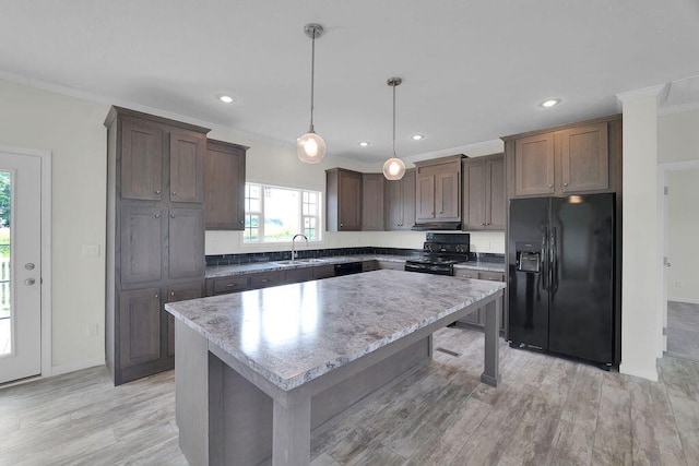 kitchen with a kitchen island, black appliances, pendant lighting, light hardwood / wood-style flooring, and sink